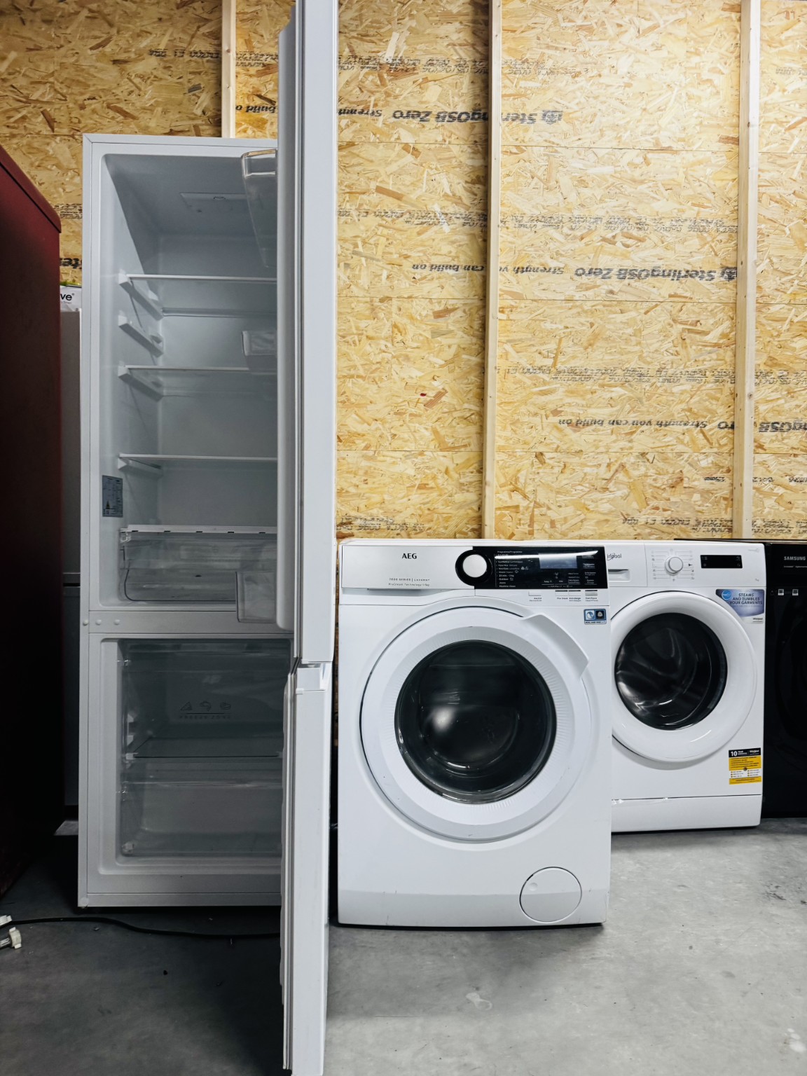 Réfrigérateur ouvert et lave-linge photographiés dans notre atelier